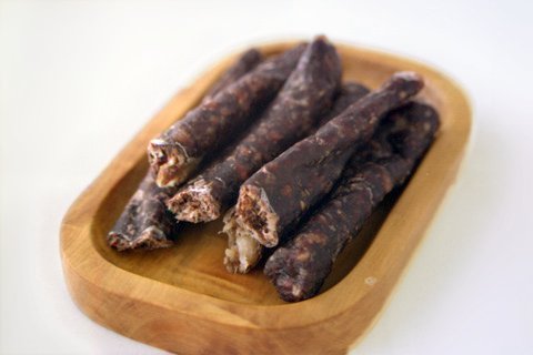 Photo of droëwors that is served on a plate made from wood.